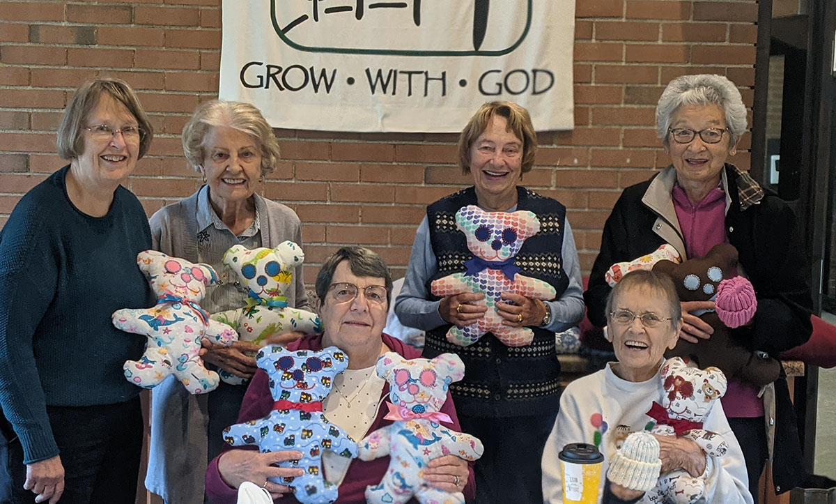 The Sewing Group from St. James Lutheran Church, Lake Forest, display the teddy bears and baby hats that they make for children in LSSI programs.